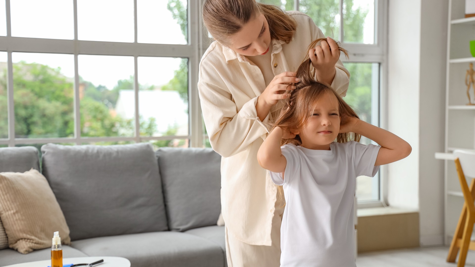 Parent carefully checking a child scalp during a head lice outbreak