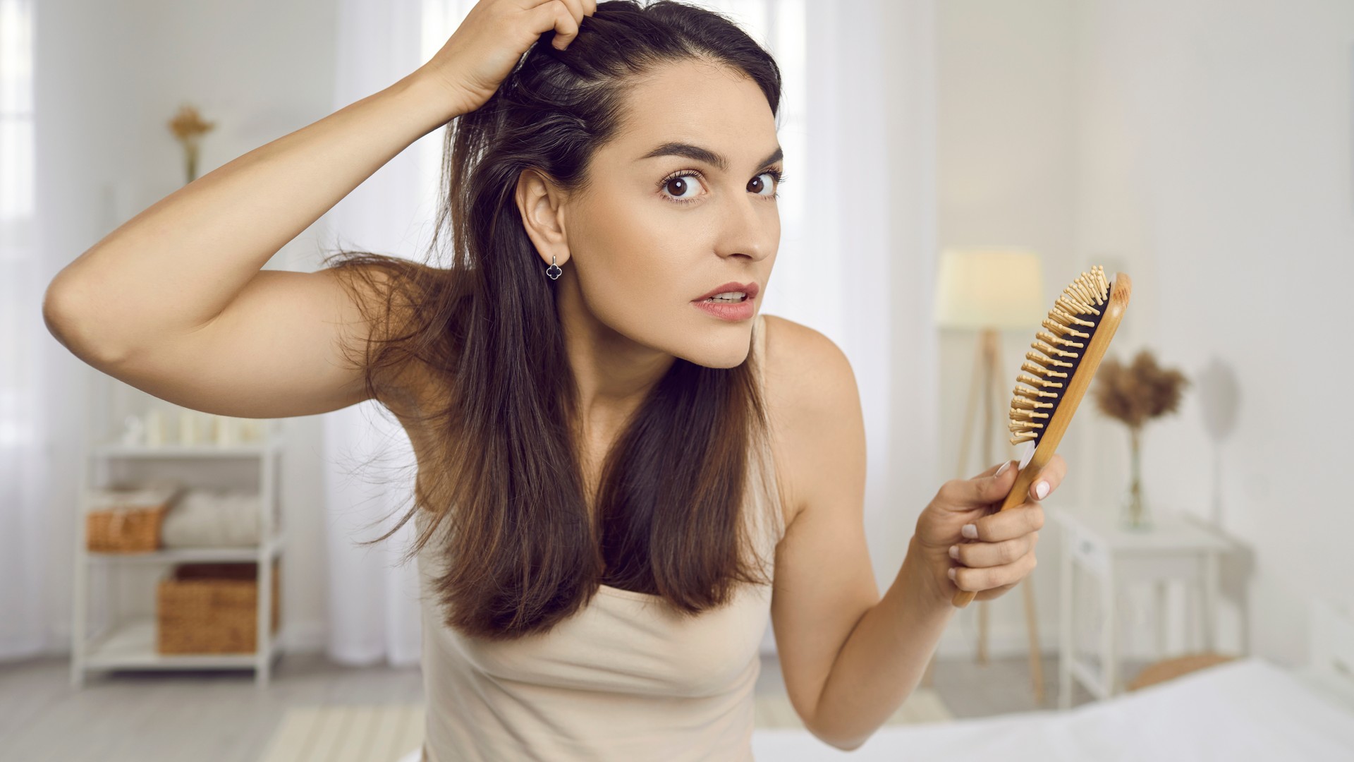 Adult woman checking her hair and scalp for signs of head lice
