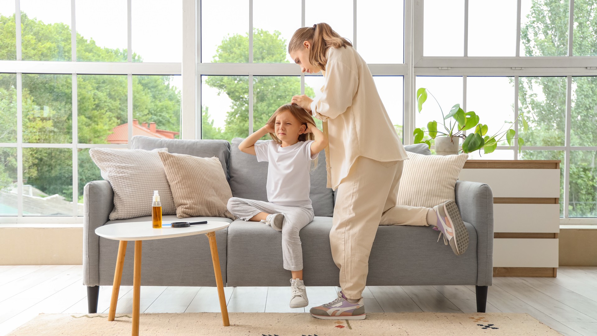 Mother checking a child's clean hair for head lice at home