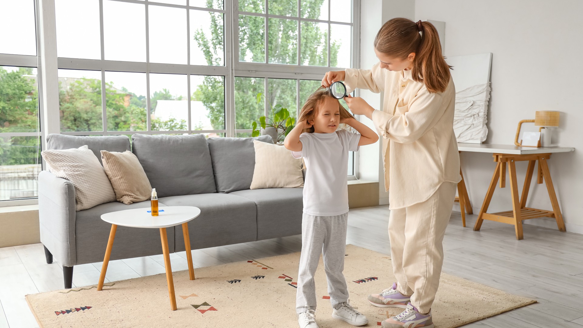 Parent using a magnifier to check a child scalp for recurring head lice